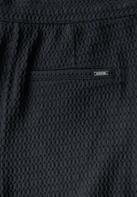 Schwarzer Stoff mit Wabenmuster und einer Gesäßtasche.